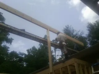 Carpenter setting a ridge beam over a new addition frame — Ice Dam Removal by Roofing Brothers in Bargersville