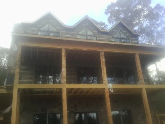 Dormers and porch framing on a large log home under construction — Roof Coating work by our crew in Bargersville